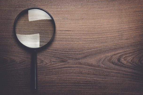 magnifying glass on wooden background - 写真・画像