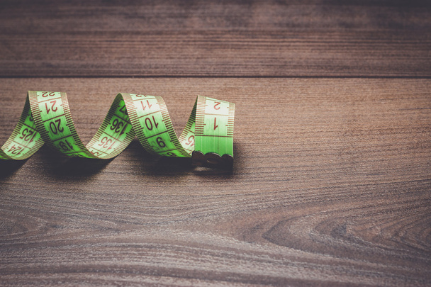 green measuring tape on wooden background - Photo, Image