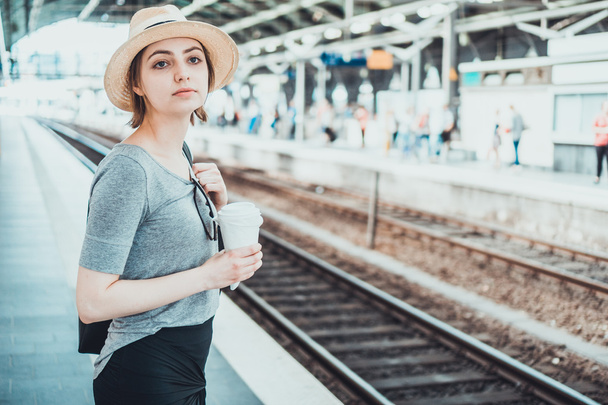 Mladá žena v šedé tričko čeká na vlakovém nádraží - Fotografie, Obrázek
