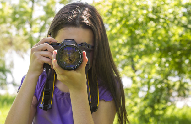 Young girl taking photos at summer green park - Fotoğraf, Görsel