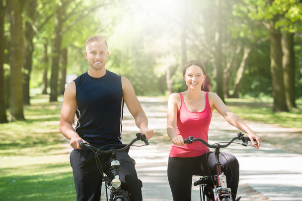Couple heureux debout avec des vélos
 - Photo, image