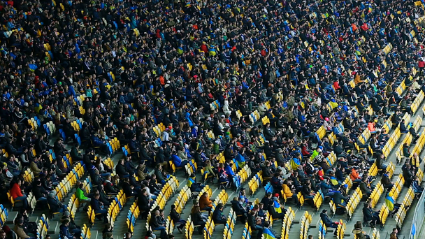 Great number of people sitting on tribunes and watching football game, stadium - Footage, Video