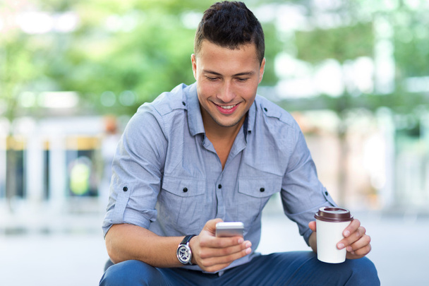 Fiatal férfi smartphone a szabadban - Fotó, kép