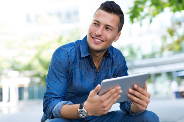 Jeune homme utilisant une tablette numérique à l'extérieur - Photo, image