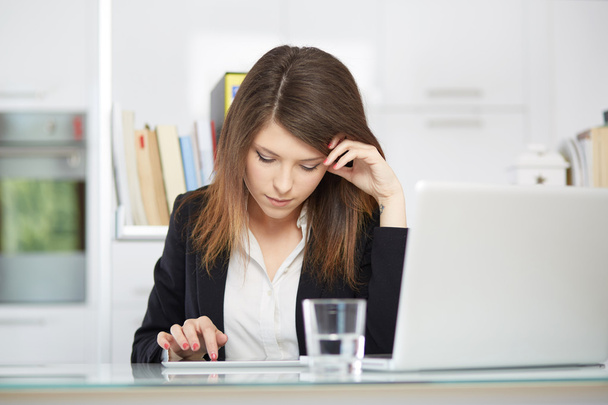 A young businesswoman is looking stressed as she works at her computer - Photo, image