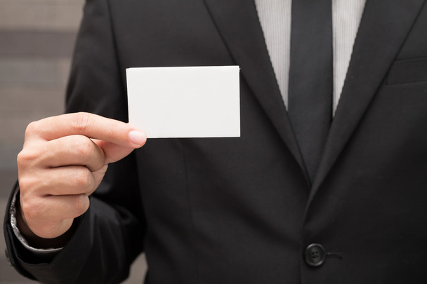 Рука бизнесмена показывает белую бумагу
 - Фото, изображение