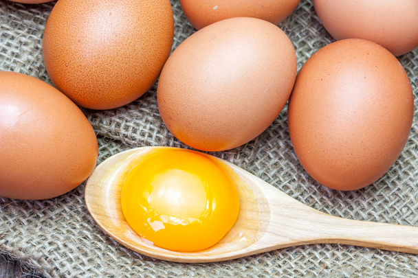 Eier und Eigelb auf braunem Sacktuch - Foto, Bild