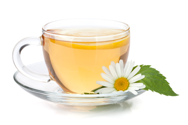 Чашка чая с ломтиком лимона, мятными листьями и цветком ромашки
 - Фото, изображение