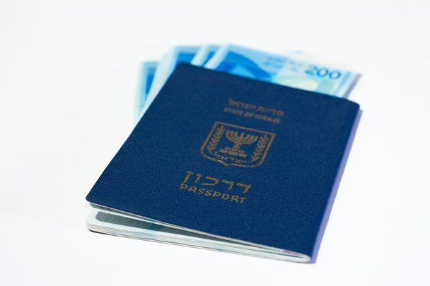 Montón de billetes israelíes de 200 shekel y pasaporte israelí
 - Foto, imagen