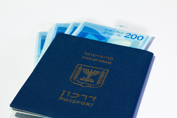 Empilhamento de contas de dinheiro israelitas de 200 shekel e passaporte israelense
 - Foto, Imagem