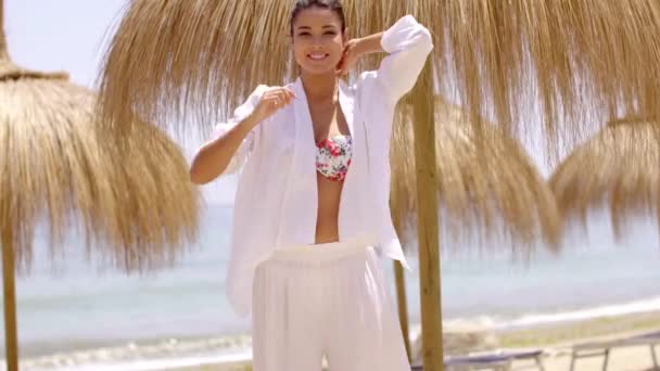 Glimlachend jonge vrouw in heldere strand kleding - Video