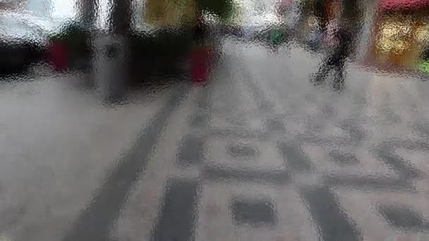 Sokak ötesinde mat cam üzerinde yürüyen insanlar - Video, Çekim