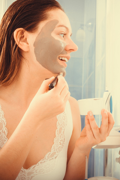 Woman applying mud facial mask - Фото, изображение