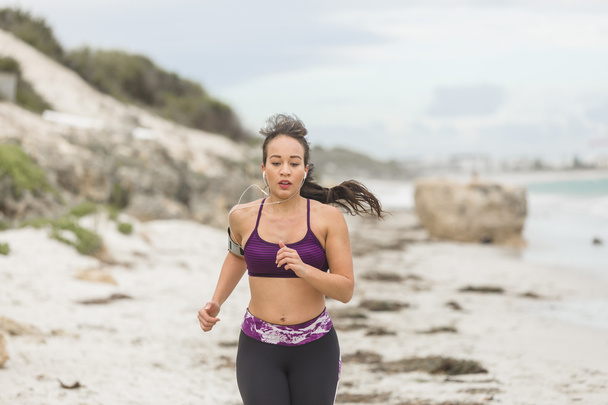 Fitness Woman Running by the Ocean at cloudy winter day - Photo, image