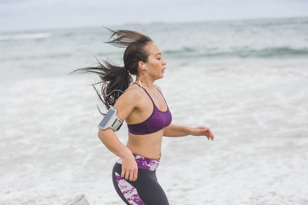 Młodych kobiet biegacza jogging na plaży. Pasuje mieszane ra - Zdjęcie, obraz