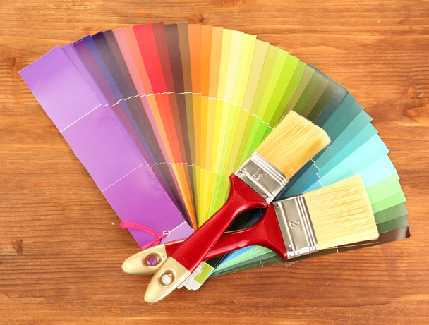 Paint brushes and bright palette of colors on wooden background - Photo, Image