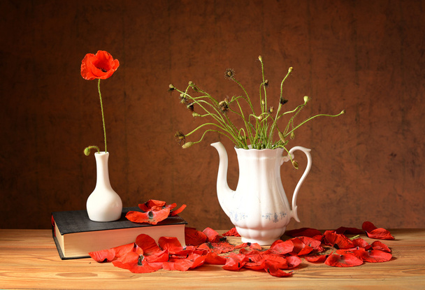 Caiu flores com as papoilas vermelhas, livros e um vaso
 - Foto, Imagem