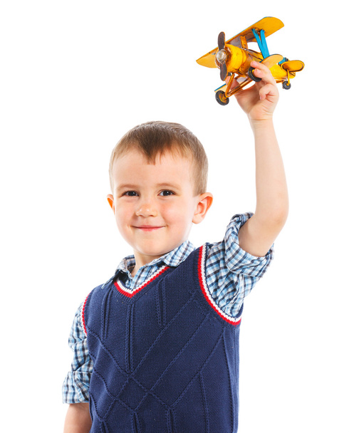 schattige kleine jongen speelt met een vliegtuig speelgoed - Foto, afbeelding
