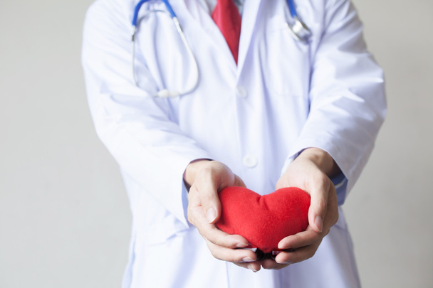 Dottore dando un oggetto a forma di cuore in sfondo bianco isolato
 - Foto, immagini
