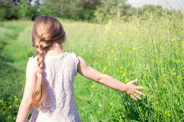 Little girl walks in the field  - Foto, afbeelding