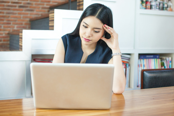 Asian woman using laptop with serious look - Photo, Image