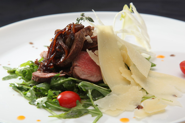 sült marhahús rucolával a tányéron olasz stílusban - Fotó, kép