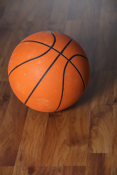 Баскетбольный мяч над деревянным полом
 - Фото, изображение
