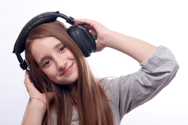 Beautiful teenage girl listens to music through the headphones - Fotografie, Obrázek