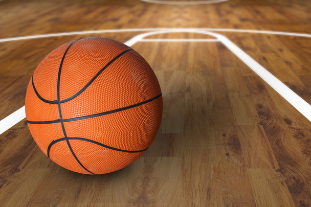 Баскетбольний м'яч над дерев'яним баскетбольним майданчиком
 - Фото, зображення