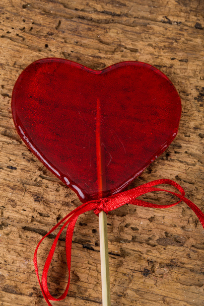 Una caramella a forma di cuore sul tavolo di legno
 - Foto, immagini