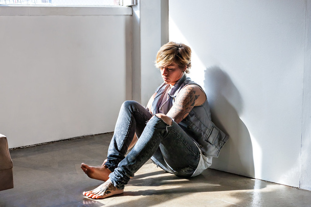 Young girl sitting on the floor with a tattoo  - Φωτογραφία, εικόνα