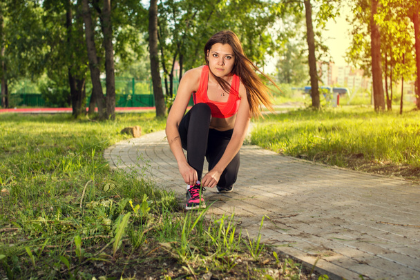 Взуття для бігу крупним планом жінка зав'язує взуття мереживами
. - Фото, зображення