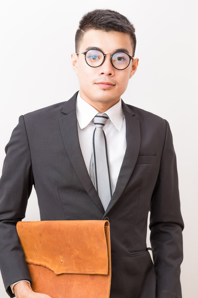 Asiatico sorridente giovane uomo d'affari occhiali portando una pulce fatta a mano
 - Foto, immagini