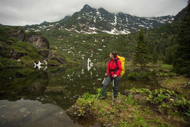 girl with backpack enjoying the view of a beautiful lake - Valokuva, kuva