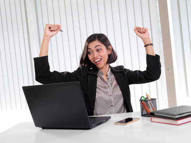 Возбужденная исполнительная женщина смотрит на ноутбук в своем офисе
 - Фото, изображение