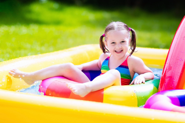 Маленька дівчинка в садовому басейні
 - Фото, зображення
