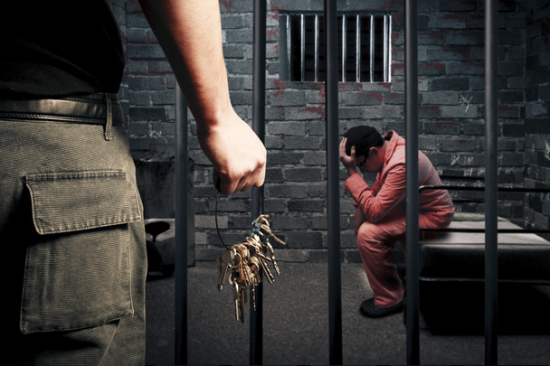 Prison guard with keys outside dark prison cell - Foto, afbeelding