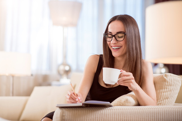 Woman drinking coffee and taking notes - Photo, image