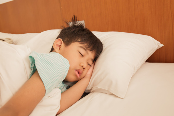 Asian boy asleep on the bed. - Φωτογραφία, εικόνα