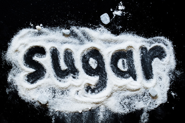 word "sugar" of white granulated sugar and powdered sugar - Fotografie, Obrázek