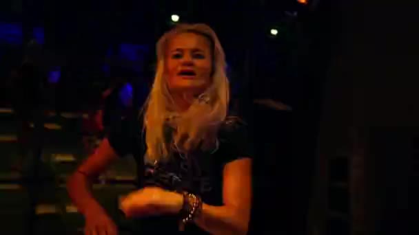 Attractive young woman dancing in a nightclub on a dancefloor - Felvétel, videó