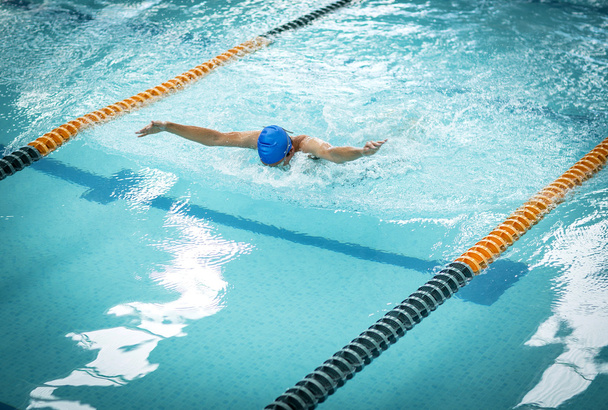 Young athletic man with butterfly swimming technique. - Foto, immagini