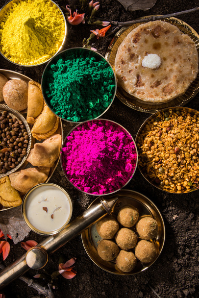 holi-festliches Essen mit Farben, indisches Festholi, samosa, kachori, laddu, gujiya, palash flower, thandai, farsan, puran poli oder roti, indisches Fest der Farben namens holi - Foto, Bild