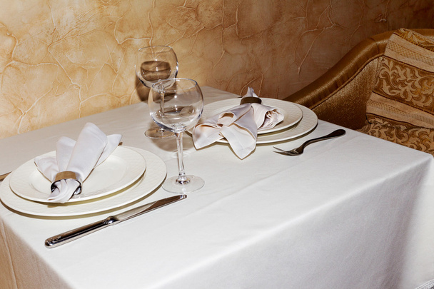 Elegant table setting with fork, knife and white napkin for two persons. A cozy cafe. - Foto, immagini