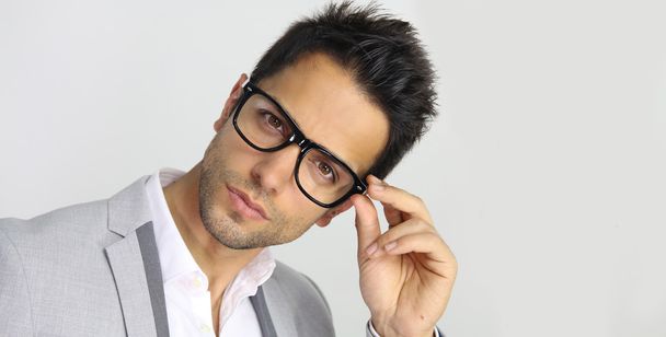 Handsome man holding eyeglasses - Foto, afbeelding