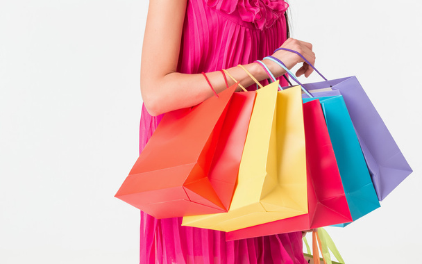 Unrecognizable woman holding multicolored shopping bags - 写真・画像