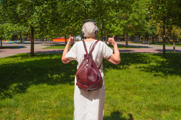 Senior šedá žena ukazuje palec v parku - Fotografie, Obrázek