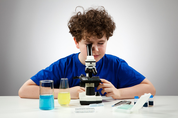 Boy examining preparation under the microscope - Fotó, kép