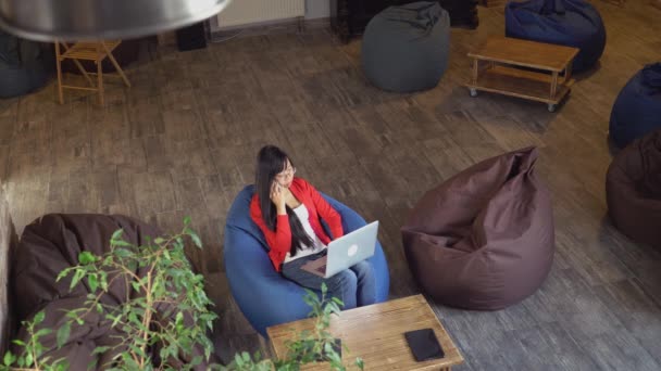 Mujer en la habitación loft con grunge interior urbano utilizando la aplicación en el teléfono inteligente
. - Imágenes, Vídeo