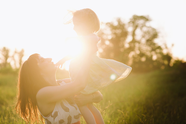Mom and daughter dancing in nature together in sunset light - Photo, Image